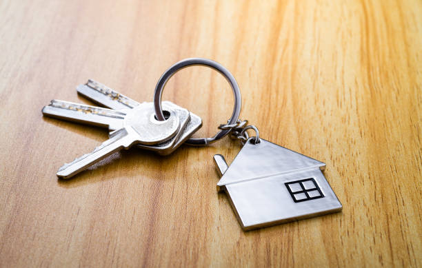 House shaped with a key on wooden table House key